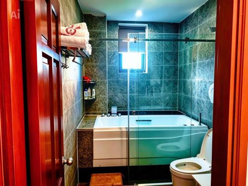 a bathroom with a bath tub and a toilet at New Conson Hotel in Con Dao
