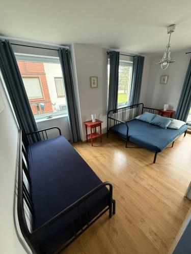 a bedroom with two beds and a large window at Apartament Łajba Łeba z basenem i kortem tenisowym in Łeba