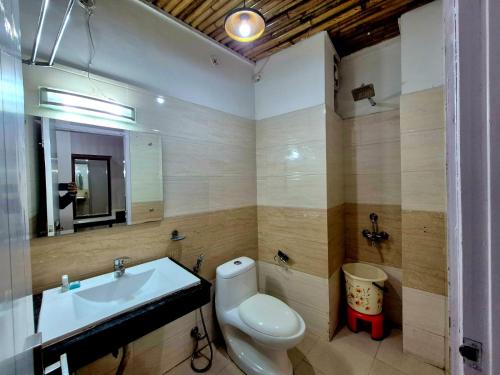 a bathroom with a sink and a toilet and a mirror at Arch Place in Gurgaon