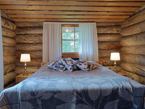 a bedroom with a bed in a log cabin at Ruska in Syöte