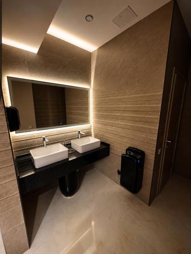 a bathroom with two sinks and a mirror at Delmont hotel in Kostanay