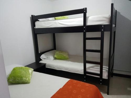 a room with two bunk beds and a bed at Aptos hermosos en sector turistico in Montenegro