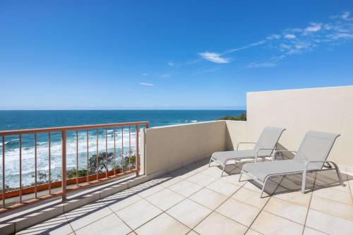a balcony with chairs and a view of the beach at Villa Seascapes in Coolum Beach