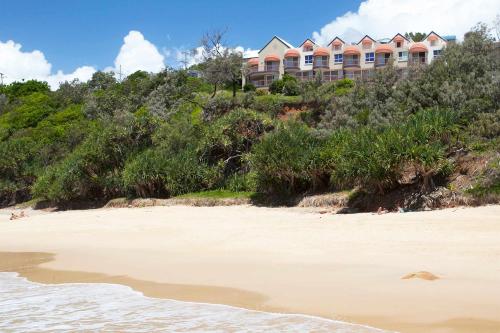 a hotel on a hill next to a beach at Villa Seascapes in Coolum Beach