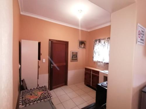 eine Küche mit einer braunen Tür und einer Spüle in der Unterkunft Skippers Backpackers CC in Walvis Bay