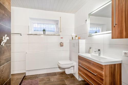 a white bathroom with a sink and a toilet at Carmen in Wald