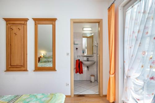 a bathroom with a sink and a mirror at Gästehaus Ursula in Hornberg