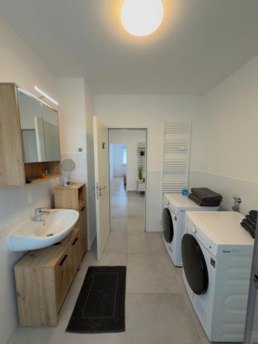 a bathroom with a sink and a washing machine at FEWOHOME Lothe Schieder Schwalenberg Schiedersee in Schieder-Schwalenberg