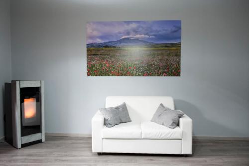 a living room with a white couch and a field of flowers at Bed & Breakfast Ellenica in Rionero in Vulture