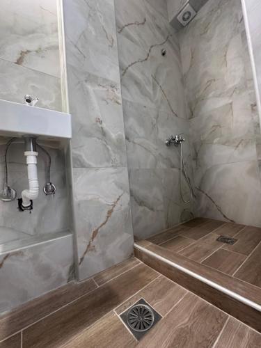 a bathroom with a shower and a sink at Olympus Apartments in Paralia Katerinis