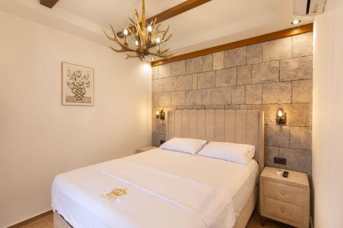 a bedroom with a white bed and a chandelier at Villa President 3 in Krimovice