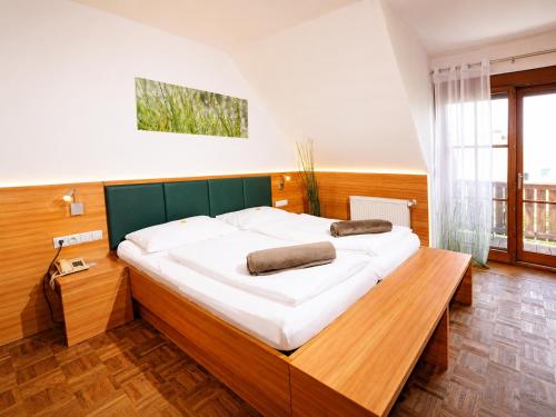 a bedroom with a large bed with a wooden headboard at Sattlerhof Genießerhotel & Weingut in Gamlitz