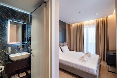 a hotel room with a bed and a bathroom at Zurich Hotel in Ksamil