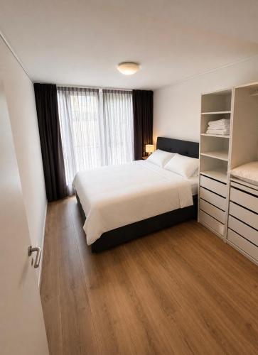 a bedroom with a bed and a large window at Noordwijk BB228 in Noordwijk