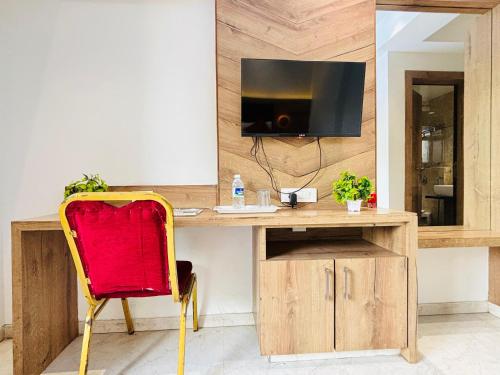 a desk with a television and a red chair at Pancharatna Regency in Chinchwad