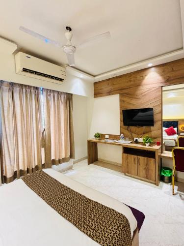 a hotel room with a bed and a television at Pancharatna Regency in Chinchwad