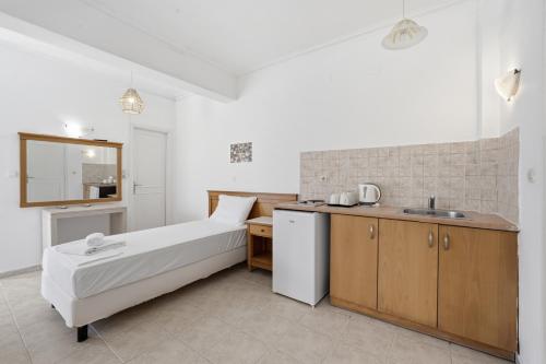 a small bedroom with a bed and a kitchen at The Kavos Sandy Inn in Kavos