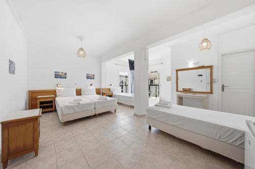 a bedroom with two beds and a living room at The Kavos Sandy Inn in Kavos