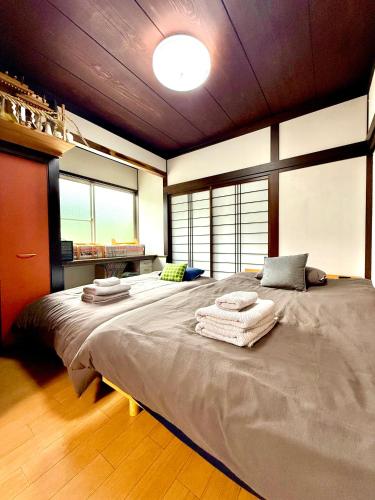 a bedroom with a large bed with towels on it at Takumisou1 in Kiso
