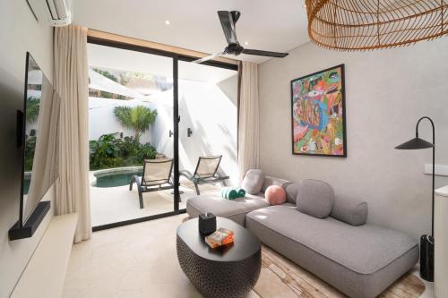 a living room with a couch and a table at The Arc House Canggu in Canggu