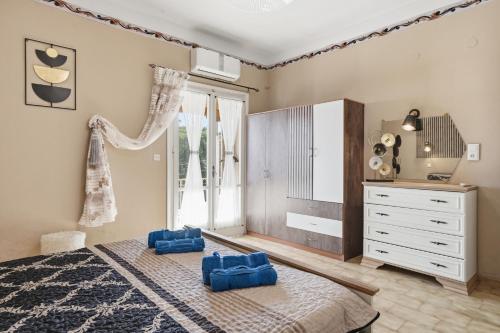 a bedroom with a bed and a dresser and a window at Mermaids By The Sea in Mesongi