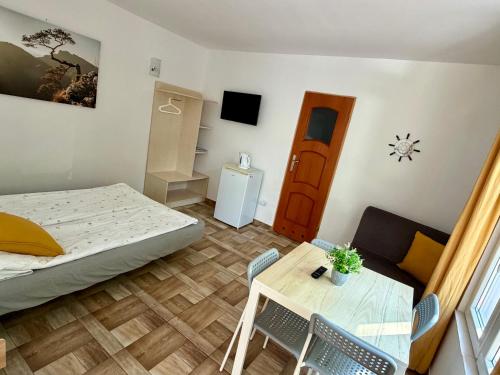 a small room with a bed and a table at Róża Wiatrów in Sztutowo