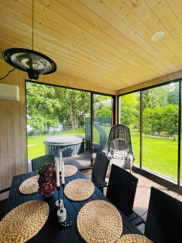 a dining room with a table and chairs and a patio at Lake House in Telšiai