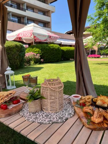 a picnic table with bread and food on it at Hotel Sevtopolis Medical & SPA in Pavel Banya