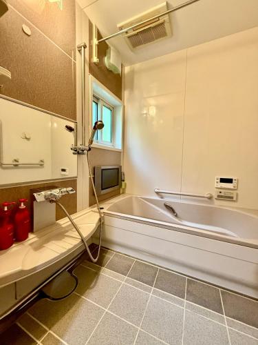 a bathroom with a bath tub and a sink at Takumisou1 in Kiso