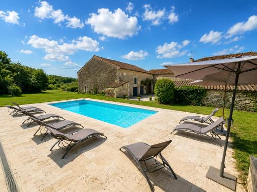 an outdoor swimming pool with chairs and an umbrella at La spacieuse maison des miots in Saint-Simeux