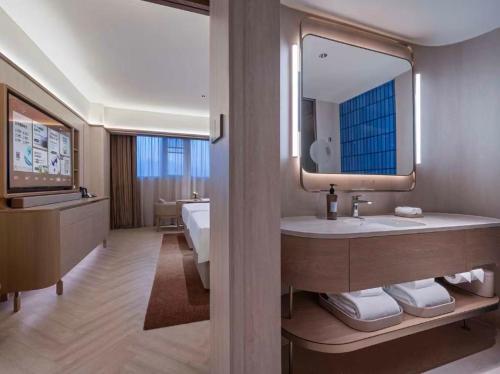 a bathroom with a sink and a large mirror at Orange Crystal Hotel Ningbo Ninghai in Ninghai