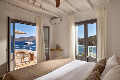 a bedroom with a bed and a view of the ocean at Villa Soleil - Delmar Collection in Adamantas