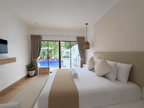 a bedroom with a large bed with a view of a pool at Pineale Villas, Resort and Spa in Panglao Island