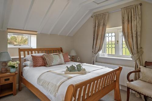 a bedroom with a large bed and a chair at The Gatehouse at Pudleston Court in Hatfield