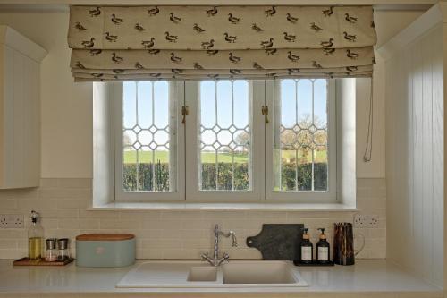 a window in a kitchen with a sink and a window shade at The Gatehouse at Pudleston Court in Hatfield
