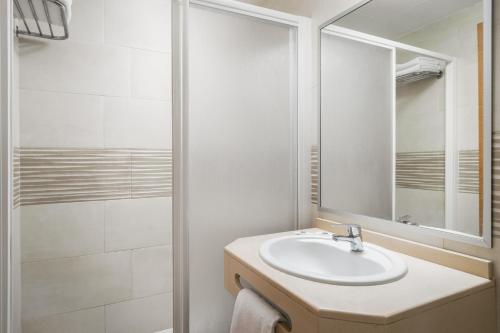 a white bathroom with a sink and a shower at Hotel Festa Brava by ALEGRIA in Lloret de Mar