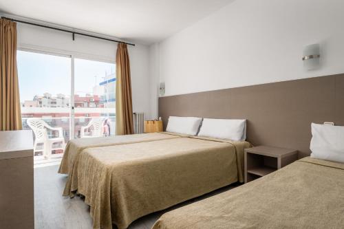 a hotel room with two beds and a large window at Hotel Festa Brava by ALEGRIA in Lloret de Mar