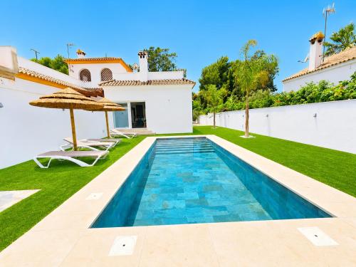a swimming pool in the backyard of a villa at Playa Fuente del Gallo I in Conil de la Frontera