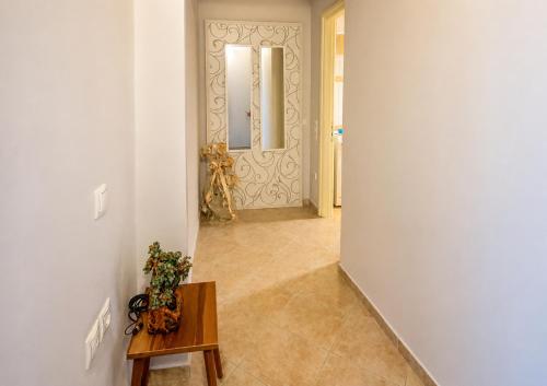a hallway with a table and a door with a mirror at Granny's Home in Roussopoúlion