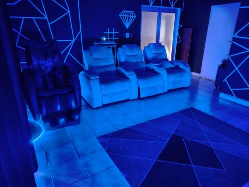 a blue room with chairs and a table in it at The Corner Lounge - Lenasia in Lenasia