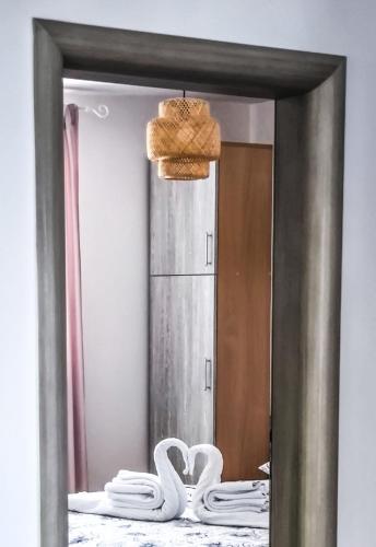 a mirror with towels on a bed in a room at Maestral in Nerezine