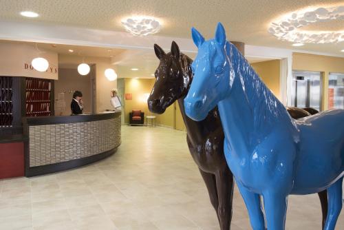 a statue of two horses in a lobby at DOMITYS – Le Carroussel in Cabourg