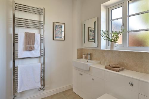 a white bathroom with a sink and a mirror at Ponds View at Pudleston Court in Docklow