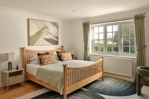 a bedroom with a bed and two windows at Ponds View at Pudleston Court in Docklow