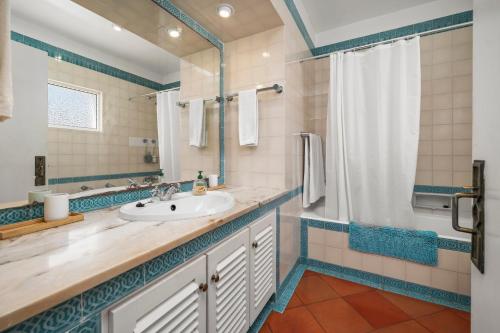 a bathroom with a sink and a shower at Prainha Alvor - Cozy Villa in Alvor