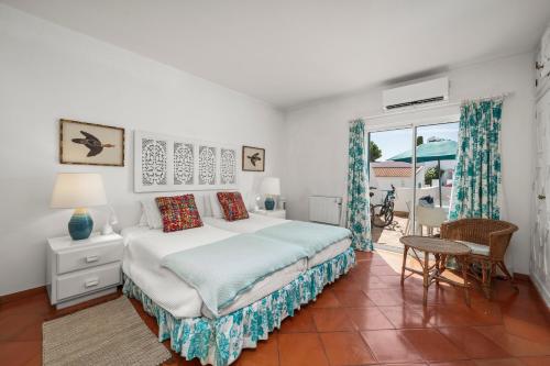 a bedroom with a large bed and a balcony at Prainha Alvor - Cozy Villa in Alvor