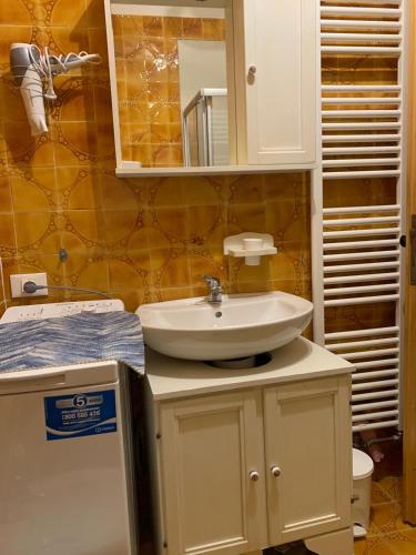 a bathroom with a sink and a mirror at Appartamento centrale Sappada in Sappada