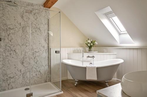 a bathroom with a tub and a glass shower at Rosehaven House at Pudleston Court in Docklow