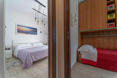 a bedroom with a bed with a red blanket at VIOLA CON SERVIZIO SPIAGGIA - LIDO ADRIANO in Lido Adriano