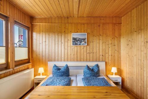 a sauna with blue pillows and a wooden wall at Bergpanorama Ruhla in Ruhla
